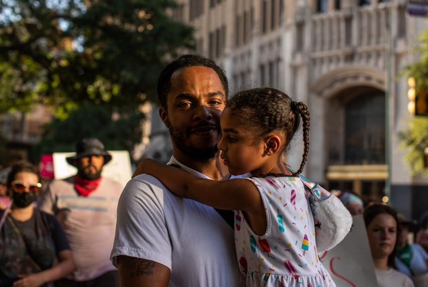 A man carries his daughter during a pro-abortion protest outside the Federal Courthouse in San Antonio on June 24, 2022.
